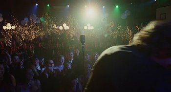 Movie still from “Jennifer's Body” (2009), directed by Karyn Kusama – A crowd of people watching a person sing; Wide shot, Over the shoulder angle