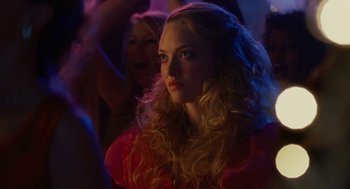 Movie still from “Jennifer's Body” (2009), directed by Karyn Kusama – A woman with long blonde curly hair in a crowd of onlookers; Close Up shot, Over the shoulder angle