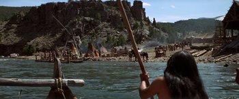 Movie still from “Jeremiah Johnson” (1972), directed by Sydney Pollack – A man holding a spear while standing on a boat; Wide shot, High angle