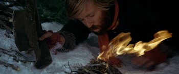 Movie still from “Jeremiah Johnson” (1972), directed by Sydney Pollack – A man laying on the ground with a fire in his hand; Close Up shot, High angle
