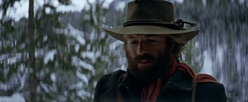 Movie still from “Jeremiah Johnson” (1972), directed by Sydney Pollack – A man with a beard wearing a cowboy hat; Close Up shot, Over the shoulder angle
