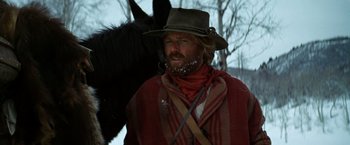 Movie still from “Jeremiah Johnson” (1972), directed by Sydney Pollack – A man with a beard and a cowboy hat and a black horse; Medium shot, Low angle