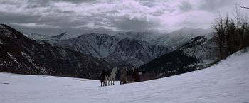 Movie still from “Jeremiah Johnson” (1972), directed by Sydney Pollack – A group of horses standing on top of a snow covered slope; Extreme Wide shot, Low angle