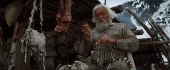 Movie still from “Jeremiah Johnson” (1972), directed by Sydney Pollack – An old man with a beard is holding a fork; Medium shot, Low angle