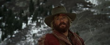 Movie still from “Jeremiah Johnson” (1972), directed by Sydney Pollack – A man with a beard wearing a hat and a scarf; Close Up shot, Low angle