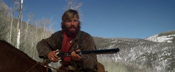 Movie still from “Jeremiah Johnson” (1972), directed by Sydney Pollack – A man holding a gun while sitting on a horse; Medium shot, Low angle