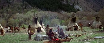 Movie still from “Jeremiah Johnson” (1972), directed by Sydney Pollack – A group of native americans sitting in a grassy area; Wide shot, High angle