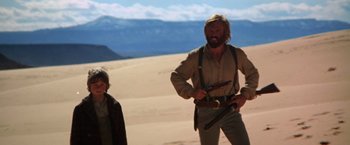 Movie still from “Jeremiah Johnson” (1972), directed by Sydney Pollack – A man and a woman standing in the desert; Medium shot, Low angle