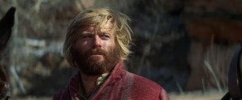 Movie still from “Jeremiah Johnson” (1972), directed by Sydney Pollack – A man with long hair and a beard is looking at the camera; Close Up shot, Low angle