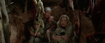 Movie still from “Jeremiah Johnson” (1972), directed by Sydney Pollack – A group of people sitting in the dirt; Medium shot, High angle