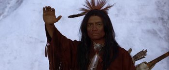 Movie still from “Jeremiah Johnson” (1972), directed by Sydney Pollack – A man in a native american costume holding a feather; Close Up shot, Low angle