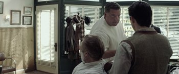 Movie still from “Jersey Boys” (2014), directed by Clint Eastwood – A man getting his hair cut by another man; Medium shot, Over the shoulder angle