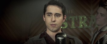 Movie still from “Jersey Boys” (2014), directed by Clint Eastwood – A man with a microphone in front of a wall; Close Up shot, Low angle