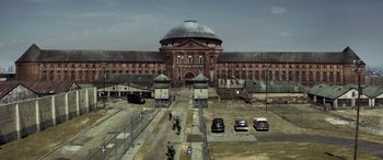 An aerial view of an old building with cars parked in front of it