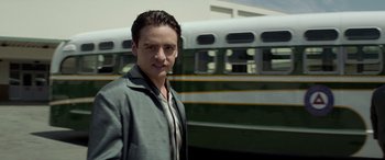 Movie still from “Jersey Boys” (2014), directed by Clint Eastwood – A man standing in front of a green bus; Medium shot, Low angle