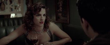 Movie still from “Jersey Boys” (2014), directed by Clint Eastwood – A woman sitting at a table holding a glass of wine; Close Up shot, Over the shoulder angle