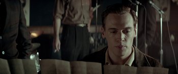 Movie still from “Jersey Boys” (2014), directed by Clint Eastwood – A man sitting in front of a sheet of paper; Close Up shot, Low angle