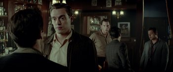 Movie still from “Jersey Boys” (2014), directed by Clint Eastwood – A man standing in front of a mirror in a bar; Medium shot, Over the shoulder angle