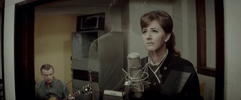 Movie still from “Jersey Boys” (2014), directed by Clint Eastwood – A woman sitting in front of a microphone in a room; Close Up shot, High angle