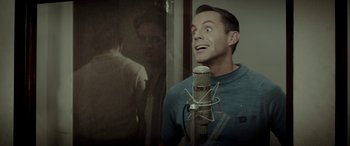 Movie still from “Jersey Boys” (2014), directed by Clint Eastwood – A man standing in front of a microphone and a mirror; Close Up shot, Over the shoulder angle