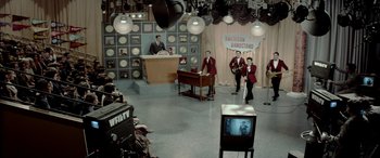 Movie still from “Jersey Boys” (2014), directed by Clint Eastwood – A television set in a television studio with people standing around it; Extreme Wide shot, High angle