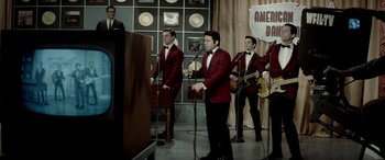Movie still from “Jersey Boys” (2014), directed by Clint Eastwood – A group of men standing in front of microphones in a room; Wide shot, High angle