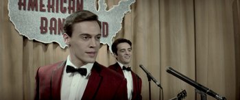 Movie still from “Jersey Boys” (2014), directed by Clint Eastwood – Two young men in tuxedos stand in front of a microphone; Close Up shot, High angle