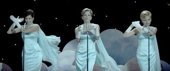 Movie still from “Jersey Boys” (2014), directed by Clint Eastwood – A woman in a white dress holding a microphone; Medium shot, Low angle