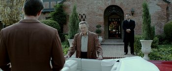 Movie still from “Jersey Boys” (2014), directed by Clint Eastwood – A man standing in front of a brick building; Wide shot, Over the shoulder angle