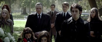Movie still from “Jersey Boys” (2014), directed by Clint Eastwood – A group of men in suits and ties standing next to each other in a park; Medium shot, Over the shoulder angle