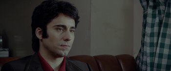 Movie still from “Jersey Boys” (2014), directed by Clint Eastwood – A person sitting on a couch; Close Up shot, High angle