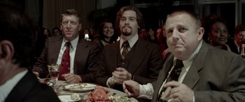 Movie still from “Jersey Boys” (2014), directed by Clint Eastwood – A group of people sitting at a table with plates of food on it; Medium shot, Over the shoulder angle
