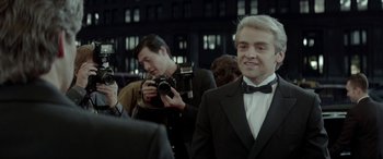 Movie still from “Jersey Boys” (2014), directed by Clint Eastwood – A man in a tuxedo is taking a picture of another man; Close Up shot, Over the shoulder angle