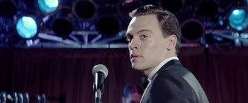 Movie still from “Jersey Boys” (2014), directed by Clint Eastwood – A man standing in front of a microphone in front of a crowd; Close Up shot, Low angle