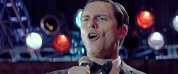 Movie still from “Jersey Boys” (2014), directed by Clint Eastwood – A person singing into a microphone; Close Up shot, Over the shoulder angle