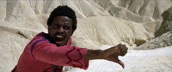 Movie still from “Jesus Christ Superstar” (1973), directed by Norman Jewison – A man in a pink shirt is pointing to the camera; Close Up shot, Low angle