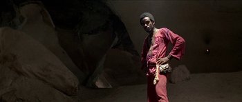 Movie still from “Jesus Christ Superstar” (1973), directed by Norman Jewison – A man standing next to an animal in a cave; Medium shot, Low angle