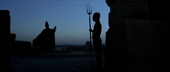 Movie still from “Jesus Christ Superstar” (1973), directed by Norman Jewison – A person holding a spear in the dark; Wide shot, Over the shoulder angle