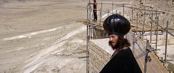 Movie still from “Jesus Christ Superstar” (1973), directed by Norman Jewison – A man with a beard wearing a black hat; Wide shot, Low angle