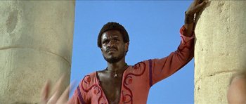 Movie still from “Jesus Christ Superstar” (1973), directed by Norman Jewison – A black man in a red and orange shirt; Medium shot, Low angle