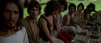 Movie still from “Jesus Christ Superstar” (1973), directed by Norman Jewison – A group of men sitting on the grass; Medium shot, Low angle