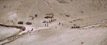 Movie still from “Jesus Christ Superstar” (1973), directed by Norman Jewison – A group of people standing on top of a sandy beach; Extreme Wide shot, High angle