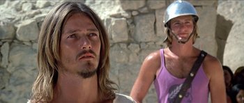 Movie still from “Jesus Christ Superstar” (1973), directed by Norman Jewison – A man with long hair and a man with a helmet on; Close Up shot, Low angle