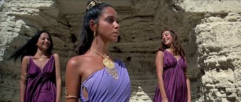 Movie still from “Jesus Christ Superstar” (1973), directed by Norman Jewison – Two women dressed in ancient roman clothing in front of a stone wall; Medium shot, Low angle