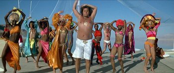 Movie still from “Jesus Christ Superstar” (1973), directed by Norman Jewison – A group of men and women dancing on the beach; Wide shot, Low angle