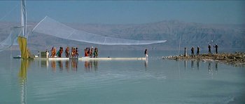 Movie still from “Jesus Christ Superstar” (1973), directed by Norman Jewison – A group of people standing on top of a body of water; Extreme Wide shot, Low angle