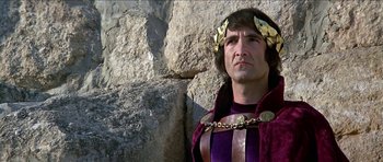 Movie still from “Jesus Christ Superstar” (1973), directed by Norman Jewison – A man wearing a crown standing in front of a rock wall; Close Up shot, Low angle