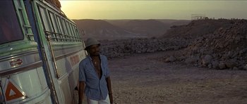 Movie still from “Jesus Christ Superstar” (1973), directed by Norman Jewison – A man standing in front of a bus on a dirt road; Wide shot, High angle