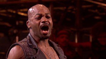 Movie still from “Jesus Christ Superstar Live in Concert” (2018), directed by Alex Rudzinski – A bald man with his mouth wide open; Close Up shot, Overhead angle