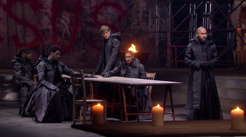 Movie still from “Jesus Christ Superstar Live in Concert” (2018), directed by Alex Rudzinski – A group of people sitting around a table with candles; Wide shot, High angle